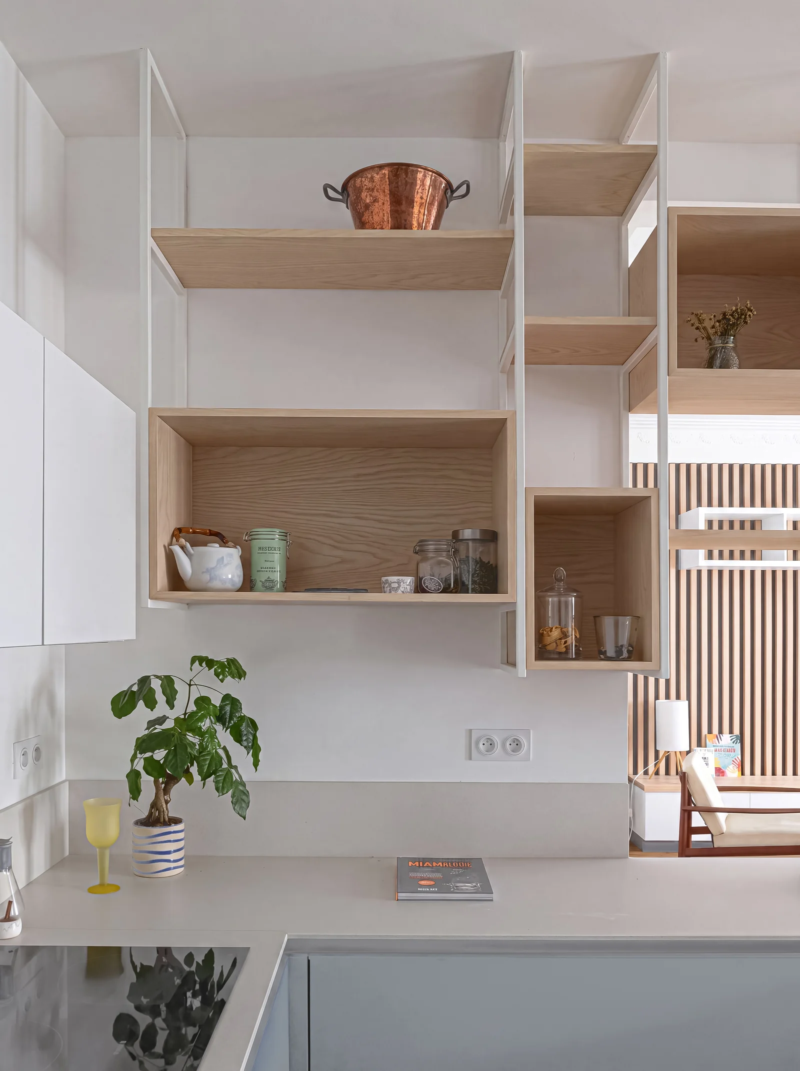 Close-up of suspended white steel shelving with oak box cubbies over a pale grey kitchen worktop