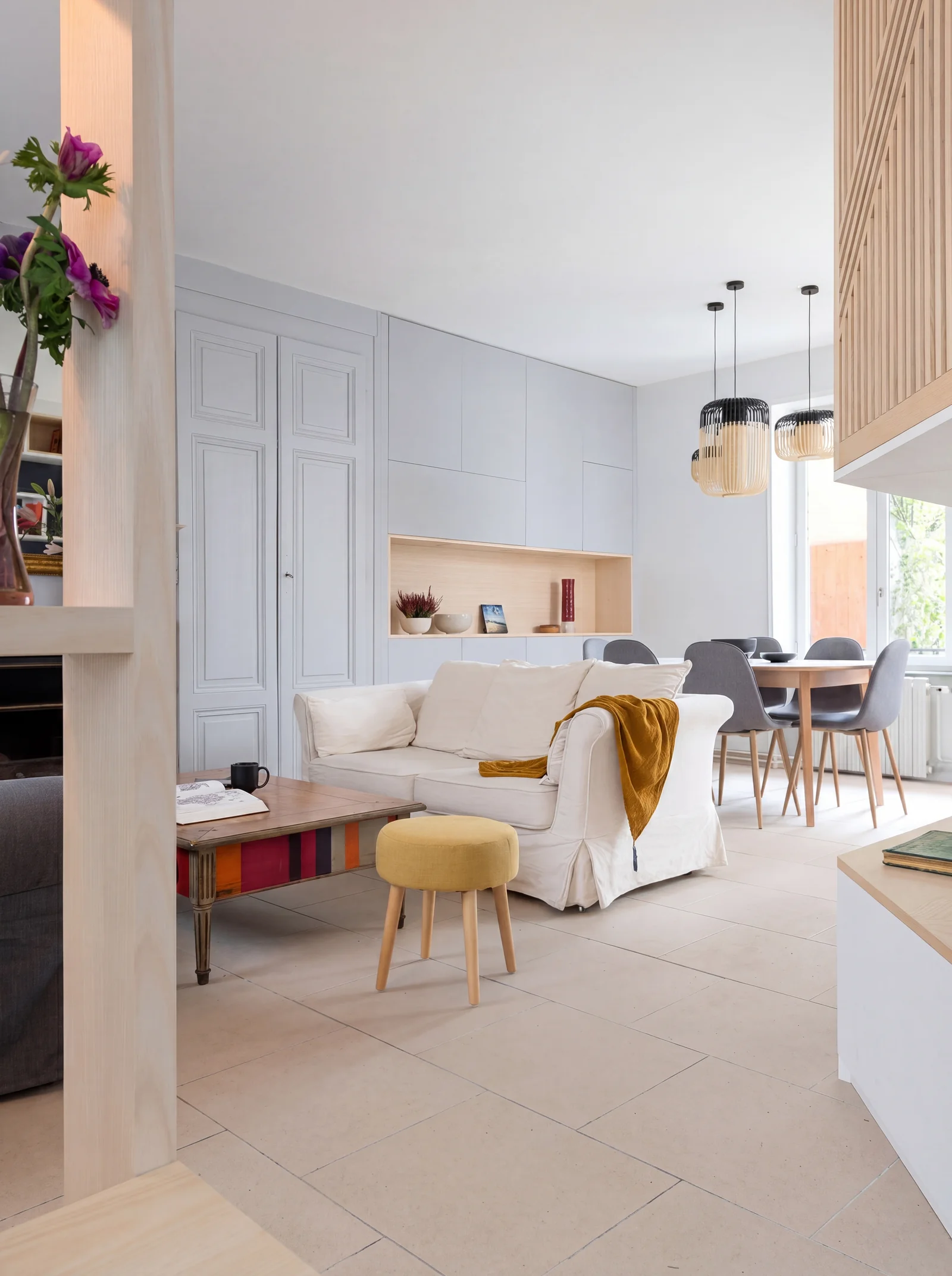Living room seen past an oak post, with pale grey built-in cupboards and a dining area beyond
