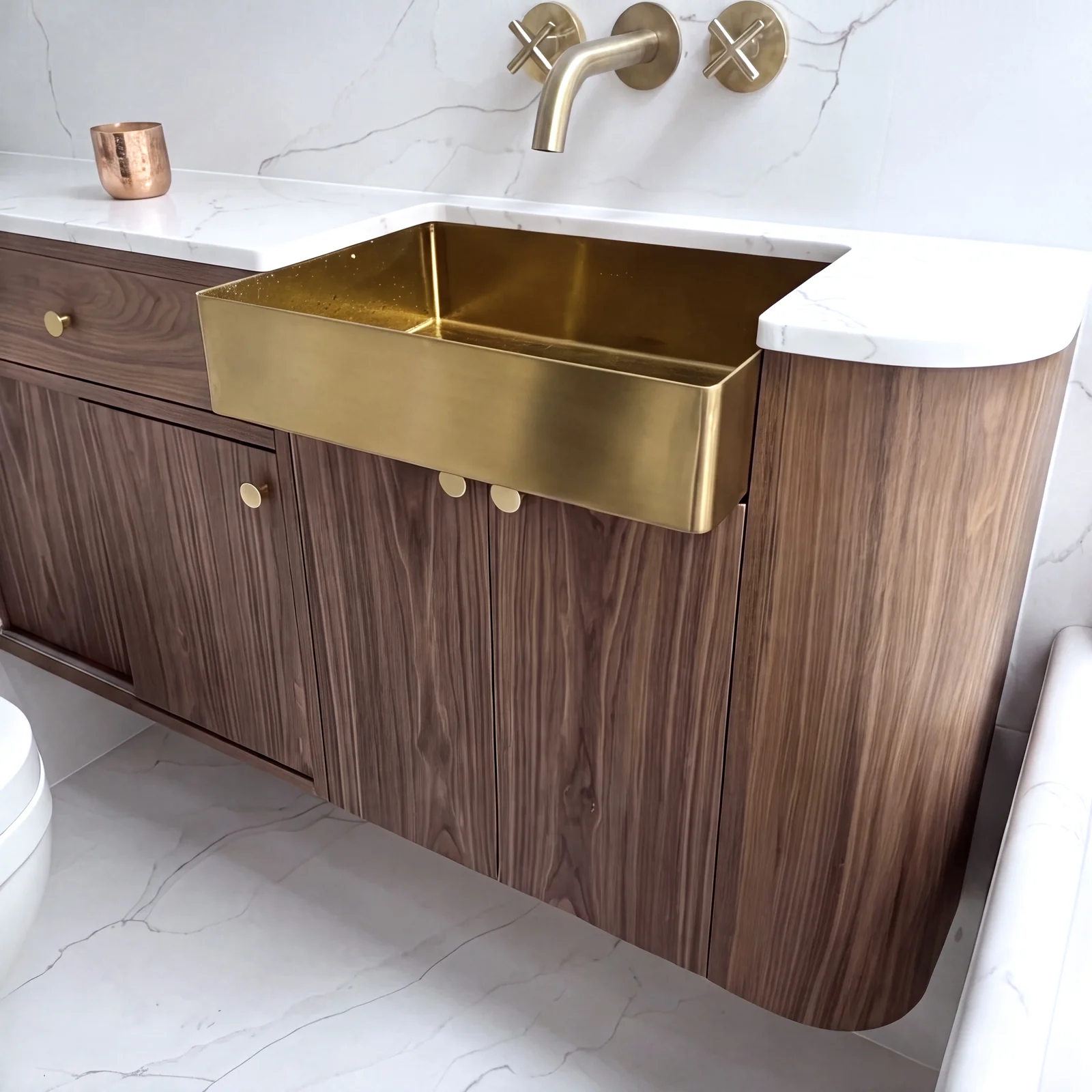 Curved walnut vanity unit with a rounded end and an inset brass basin