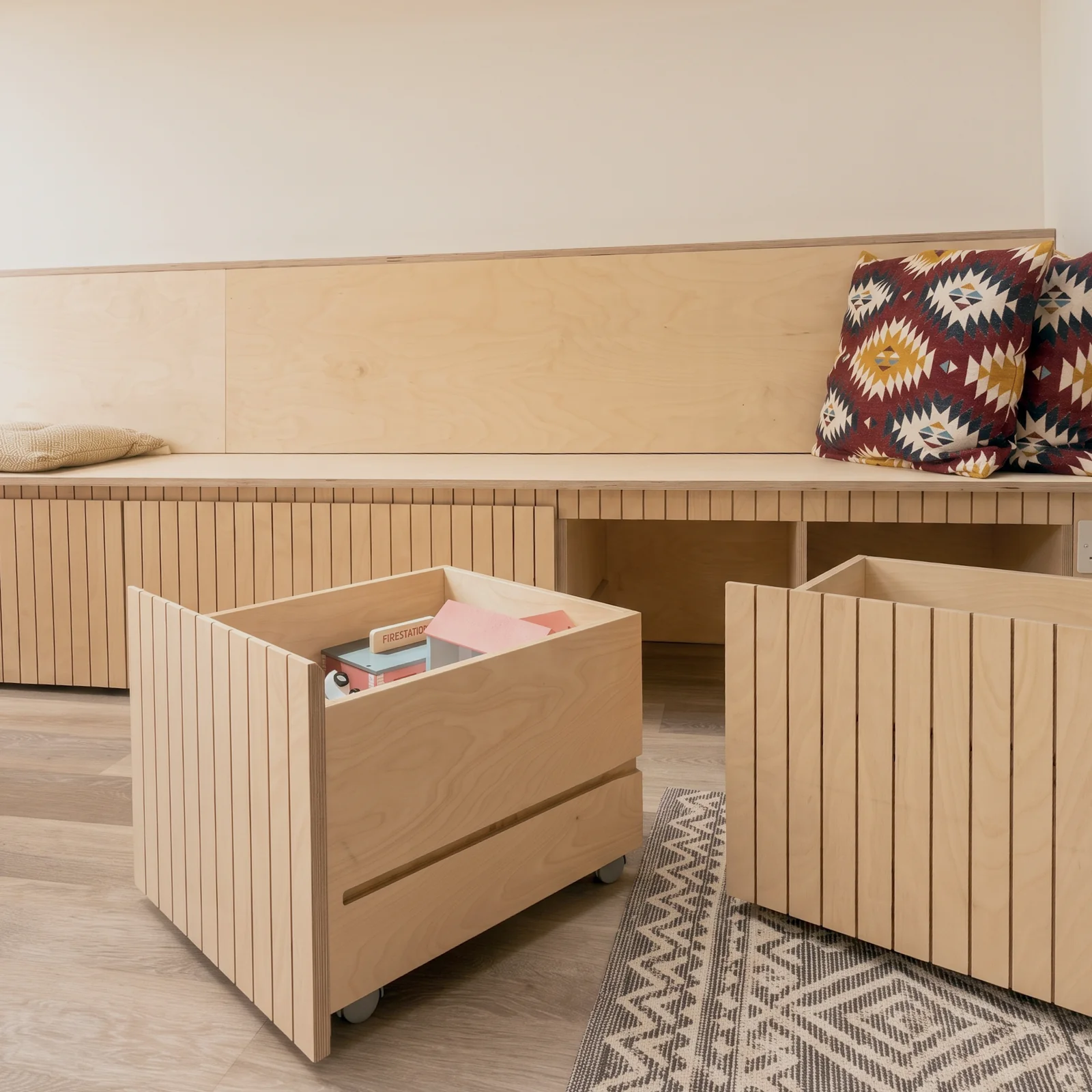 Birch ply banquette with two slatted pull-out storage drawers open beneath the seat
