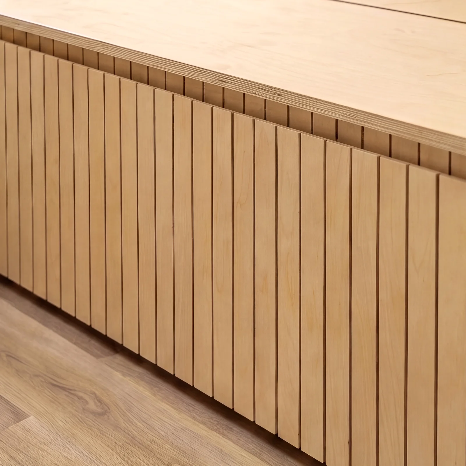 Close-up of the vertical slatted birch plywood front of a built-in bench