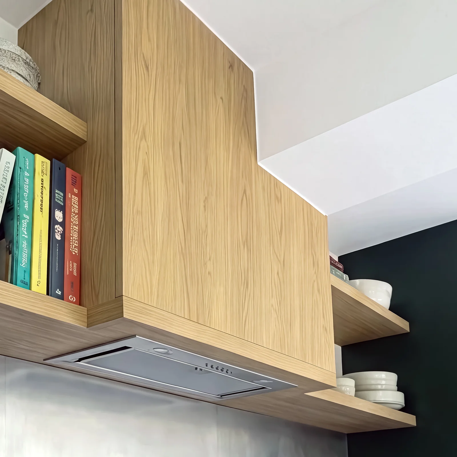 Close-up of an oak-clad extractor hood with floating oak shelves holding cookbooks