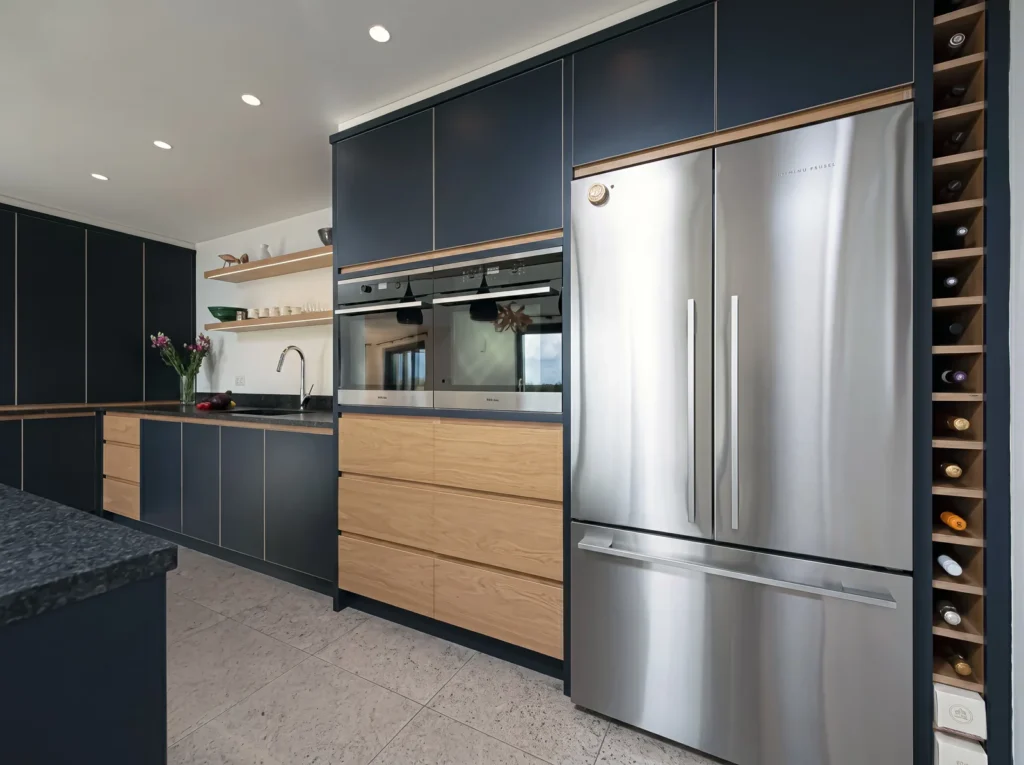 Navy and oak kitchen run with a stainless fridge freezer and a full-height wine rack