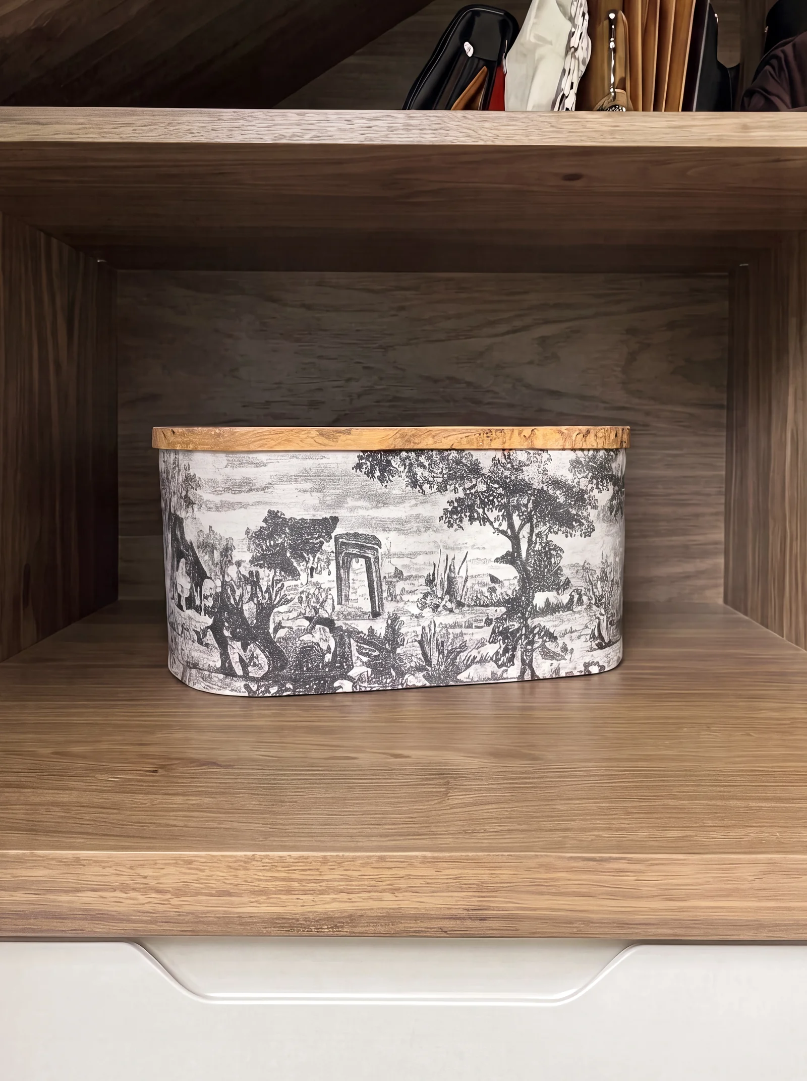 Close-up of a walnut open shelf holding a toile-printed storage box