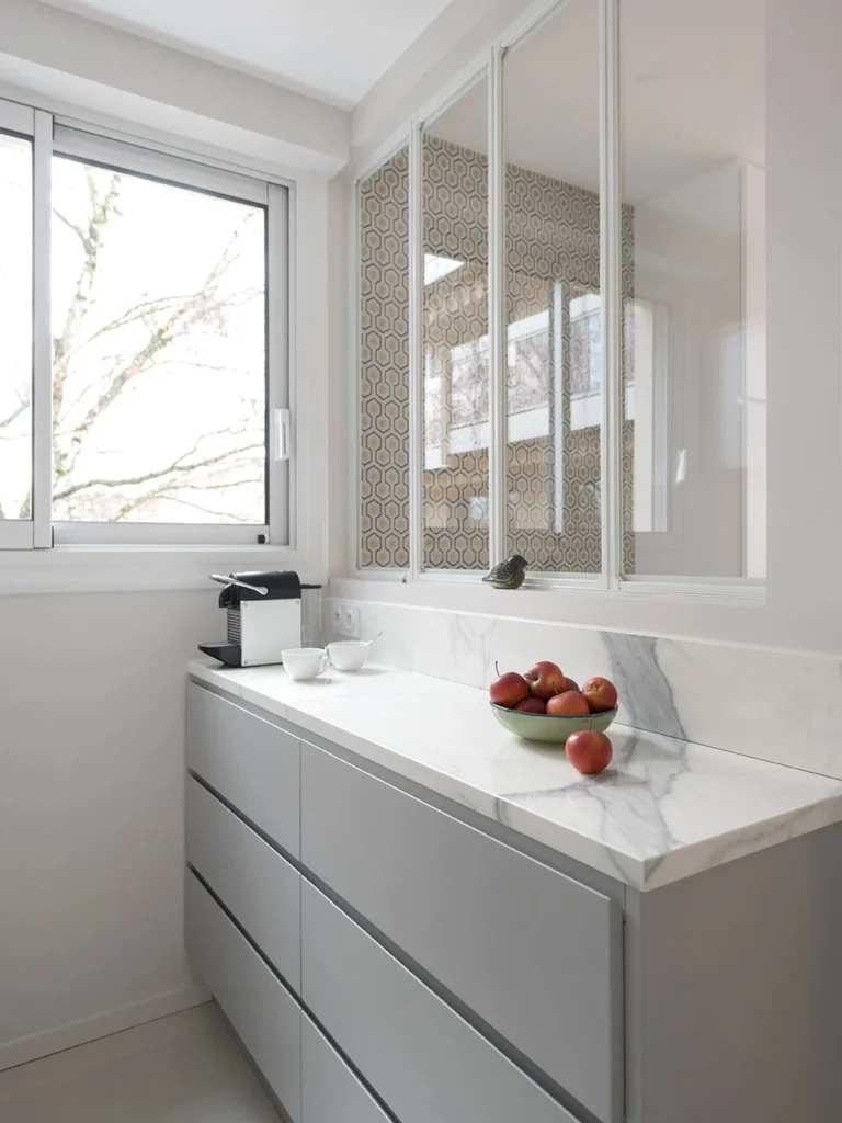 Grey handleless drawers under a white worktop with a coffee machine and fruit bowl