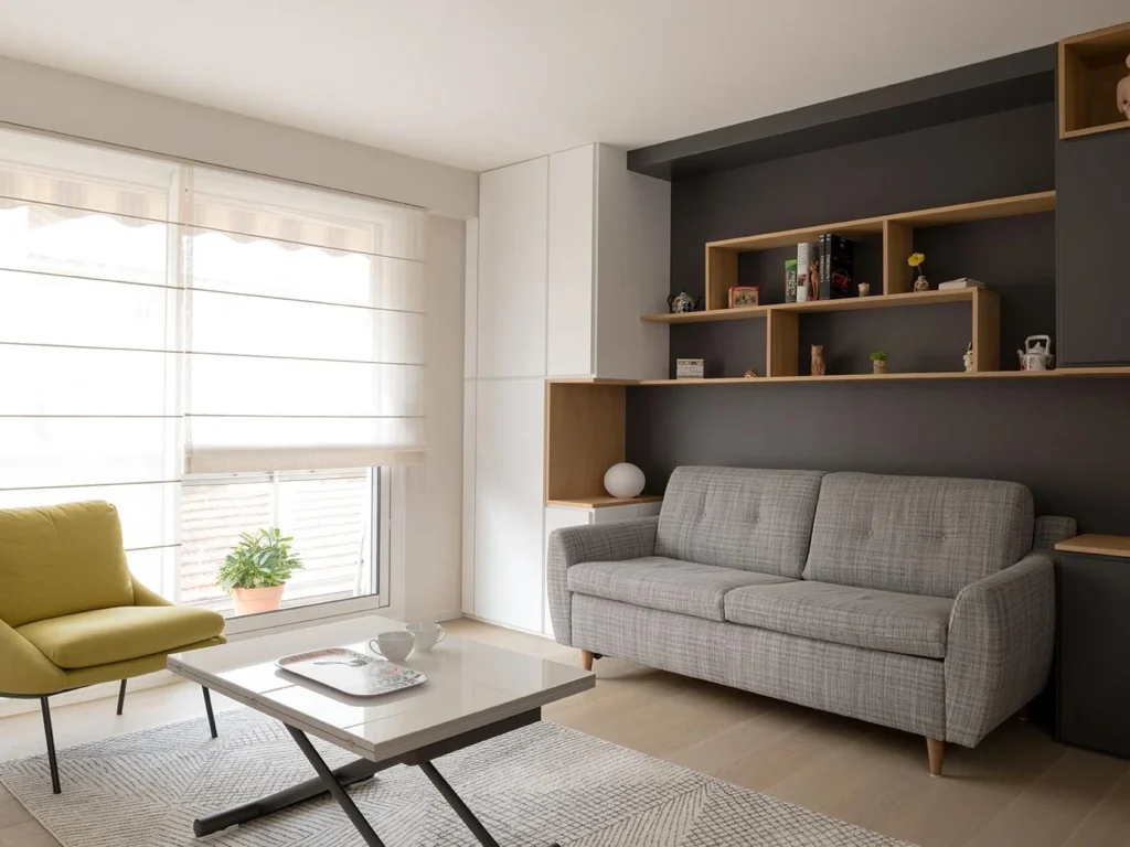 Living area with a grey sofa below dark grey shelving with open oak boxes