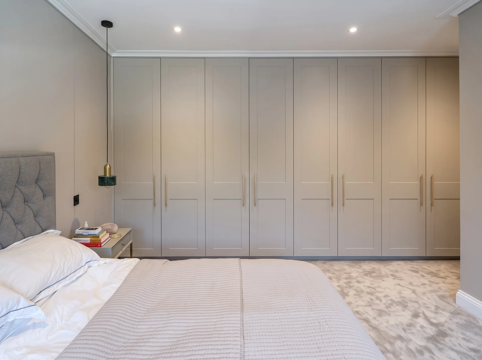 Fitted wardrobes in Chislehurst: bedroom with a full wall of pale grey shaker wardrobes facing the bed in Chislehurst